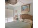 Cozy bedroom with a ceiling fan, beach-themed art, and natural light from the window at 6157 Midnight Pass Rd # E42, Sarasota, FL 34242