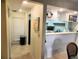 Bright hallway leading to a modern kitchen with white cabinets and a breakfast bar at 6157 Midnight Pass Rd # E42, Sarasota, FL 34242