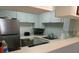 Well-maintained kitchen with stainless steel appliances and blue cabinets at 6157 Midnight Pass Rd # E42, Sarasota, FL 34242