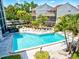 Aerial view of a community pool surrounded by lush landscaping and lounging area at 6157 Midnight Pass Rd # E42, Sarasota, FL 34242
