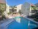 Resort-style pool area with multiple lounge chairs and a covered pavilion, surrounded by condominium buildings at 6157 Midnight Pass Rd # E42, Sarasota, FL 34242