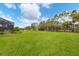 Expansive backyard showcasing lush green grass and mature trees at 6211 90Th Avenue E Cir, Parrish, FL 34219