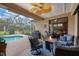 Outdoor patio with a fire pit, ceiling fan, and screened-in pool in the background at 6211 90Th Avenue E Cir, Parrish, FL 34219
