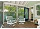 Screened-in porch with outdoor swivel chairs and views of lush landscaping at 635 Ohio Pl, Sarasota, FL 34236