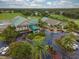 Stunning aerial view of the golf course and clubhouse entrance, beautifully landscaped with colorful flowers and palm trees at 6834 Fairview Ter # 6834, Bradenton, FL 34203