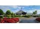 A ground-level view of the clubhouse entrance with red flowers and lush green landscaping at 6834 Fairview Ter # 6834, Bradenton, FL 34203