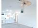 Open-concept living room with white walls and a large ceiling fan flows into the kitchen and dining area at 6834 Fairview Ter # 6834, Bradenton, FL 34203