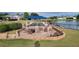 Relax in this outdoor lounge with comfortable seating, a fire pit, and a beautiful water view under a shaded pergola at 6834 Fairview Ter # 6834, Bradenton, FL 34203