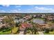 Beautiful aerial view of the home with a tile roof, located on a lake in a lush, green neighborhood at 6955 Stetson Street Cir, Sarasota, FL 34243