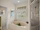 Bright bathroom featuring a soaking tub and walk-in shower at 6955 Stetson Street Cir, Sarasota, FL 34243