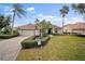 Charming single-story home with a manicured lawn, terracotta roof, and palm trees on a sunny day at 6955 Stetson Street Cir, Sarasota, FL 34243