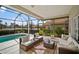 Relaxing screened lanai with comfortable seating, offering serene views of the pool and lush backyard at 6955 Stetson Street Cir, Sarasota, FL 34243