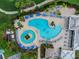 Aerial view of a community pool featuring lounge chairs, umbrellas, and lush landscaping at 7112 Marsh View Ter, Bradenton, FL 34212