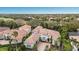 Stunning aerial view of a luxury home with a terracotta tile roof and lush landscaping in a golf course community at 7210 Desert Ridge Gln, Lakewood Ranch, FL 34202