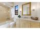 Updated bathroom with a glass enclosed tub/shower combination, neutral finishes, and a bright window at 7210 Desert Ridge Gln, Lakewood Ranch, FL 34202