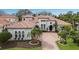 Stunning exterior showcasing a tile roof, lush landscaping, and a beautiful brick driveway at 7210 Desert Ridge Gln, Lakewood Ranch, FL 34202