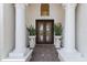 Grand entrance with detailed double doors framed by elegant columns and decorative plants at 7210 Desert Ridge Gln, Lakewood Ranch, FL 34202