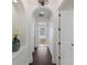 Hallway featuring hardwood floors and neutral paint, leading to the Primary bathroom at 7210 Desert Ridge Gln, Lakewood Ranch, FL 34202