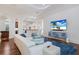 An open-concept living room with hardwood flooring, a modern fireplace, and a view to the kitchen at 7210 Desert Ridge Gln, Lakewood Ranch, FL 34202