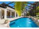 Stunning screened-in pool area with a spa, fountains, lush landscaping, and outdoor seating at 7210 Desert Ridge Gln, Lakewood Ranch, FL 34202