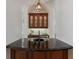 The wet bar features a dark countertop and wooden cabinets with glass doors for displaying glasses at 7210 Desert Ridge Gln, Lakewood Ranch, FL 34202