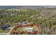 Aerial view of a property outlined in red, nestled in a lush, wooded area at 7407 226Th E St, Bradenton, FL 34211