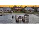 This aerial view shows a waterfront home with lush lawn, a dock, and the sparkling water that Anna Maria Island is known for at 7706 Desoto Memorial Hwy, Bradenton, FL 34209