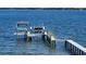 This boat dock has a covered area for relaxing with two American flags, a ladder, and a built-in jacuzzi at 7706 Desoto Memorial Hwy, Bradenton, FL 34209