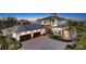 Elegant two-story home showcasing stone accents, lush landscaping, and a paved driveway leading to a two-car garage at 7706 Desoto Memorial Hwy, Bradenton, FL 34209