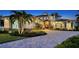 Beautiful home featuring a paved driveway, lush landscaping, and architectural details including stone accents and dormer windows at 7706 Desoto Memorial Hwy, Bradenton, FL 34209