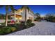 A beautiful two-story home, featuring a paver driveway, lush landscaping, and a second-story balcony at 7706 Desoto Memorial Hwy, Bradenton, FL 34209