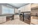 Bright laundry room with modern appliances, custom cabinetry, and stylish patterned tile flooring at 7706 Desoto Memorial Hwy, Bradenton, FL 34209