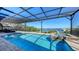 Sparkling screened pool with spa overlooking waterfront and dock at 7706 Desoto Memorial Hwy, Bradenton, FL 34209