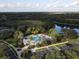 Aerial view of the community pool, clubhouse, parking lot and lake at 7723 Heyward Cir, University Park, FL 34201