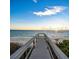 Beach access view with a boardwalk leading onto a sandy beach with ocean views and a serene sky at 813 Plymouth St, Sarasota, FL 34242