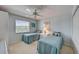 Cozy bedroom features twin beds, a ceiling fan, and a bright window at 8735 Olde Hickory Ave # 8303, Sarasota, FL 34238