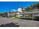 Exterior shot of a multi-story condo building with balconies, carports, and palm trees at 8735 Olde Hickory Ave # 8303, Sarasota, FL 34238