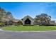 A view of the clubhouse, surrounded by manicured landscaping and mature trees at 8735 Olde Hickory Ave # 8303, Sarasota, FL 34238
