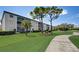 A multi-story building with screened-in balconies overlooks a lush lawn with mature trees and a winding sidewalk at 8735 Olde Hickory Ave # 8303, Sarasota, FL 34238