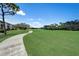 Expansive view of the meticulously maintained golf course and cart path, under a clear blue sky at 8735 Olde Hickory Ave # 8303, Sarasota, FL 34238