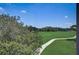 Scenic view of the meticulously maintained golf course, showcasing lush greenery and a winding cart path under a clear blue sky at 8735 Olde Hickory Ave # 8303, Sarasota, FL 34238