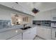 Kitchen area with white cabinets, gray countertops, and a pass-through to the living room at 8735 Olde Hickory Ave # 8303, Sarasota, FL 34238