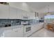 White kitchen with ample cabinet space, updated appliances, and a breakfast nook at 8735 Olde Hickory Ave # 8303, Sarasota, FL 34238
