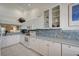 Clean kitchen featuring white cabinetry, tile backsplash, and modern appliances at 8735 Olde Hickory Ave # 8303, Sarasota, FL 34238