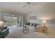 Cozy living room featuring plush carpeting, sliding doors to lanai, and ceiling fan at 8735 Olde Hickory Ave # 8303, Sarasota, FL 34238