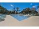 Relaxing community pool surrounded by lounge chairs and mature trees at 8735 Olde Hickory Ave # 8303, Sarasota, FL 34238