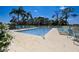 Inviting community pool surrounded by lounge chairs and beautiful landscaping at 8735 Olde Hickory Ave # 8303, Sarasota, FL 34238