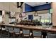Full bar area with marble counters, bar stool seating and golf course views at 8735 Olde Hickory Ave # 8303, Sarasota, FL 34238