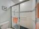 Bathroom shower with glass sliding doors, tiled walls, and safety bar at 8735 Olde Hickory Ave # 8303, Sarasota, FL 34238
