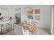 Dining room with a wooden table, modern chandelier, contemporary art, and adjacent stainless fridge at 9164 Tequila Sunrise Dr, Sarasota, FL 34241